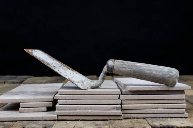 Fayans yere yerleştirmeye ilişkin. Aksesuarları ve malzemeleri Ahşap Atölyesi masanın üzerine düzenlenmiş bir inşaat işçisi. Koyu arka plan