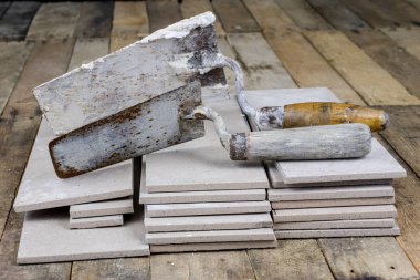 Fayans yere yerleştirmeye ilişkin. Aksesuarları ve malzemeleri Ahşap Atölyesi masanın üzerine düzenlenmiş bir inşaat işçisi. Koyu arka plan