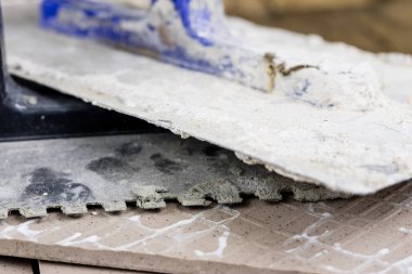 Fayans yere yerleştirmeye ilişkin. Aksesuarları ve malzemeleri Ahşap Atölyesi masanın üzerine düzenlenmiş bir inşaat işçisi. Koyu arka plan