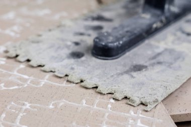 Fayans yere yerleştirmeye ilişkin. Aksesuarları ve malzemeleri Ahşap Atölyesi masanın üzerine düzenlenmiş bir inşaat işçisi. Koyu arka plan