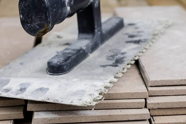 Fayans yere yerleştirmeye ilişkin. Aksesuarları ve malzemeleri Ahşap Atölyesi masanın üzerine düzenlenmiş bir inşaat işçisi. Koyu arka plan