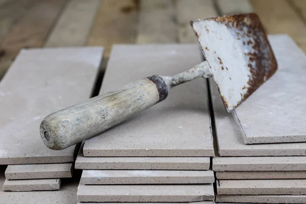 Fayans yere yerleştirmeye ilişkin. Aksesuarları ve malzemeleri Ahşap Atölyesi masanın üzerine düzenlenmiş bir inşaat işçisi. Koyu arka plan