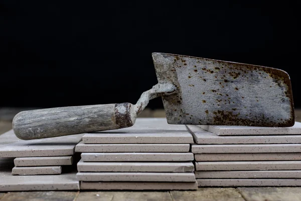 Fayans yere yerleştirmeye ilişkin. Aksesuarları ve malzemeleri Ahşap Atölyesi masanın üzerine düzenlenmiş bir inşaat işçisi. Koyu arka plan