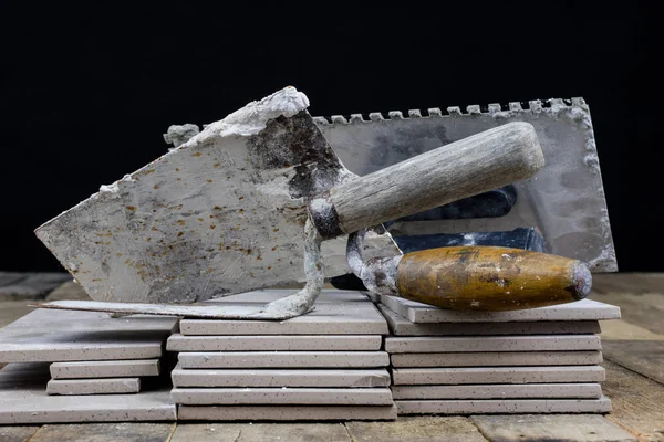 Fayans yere yerleştirmeye ilişkin. Aksesuarları ve malzemeleri Ahşap Atölyesi masanın üzerine düzenlenmiş bir inşaat işçisi. Koyu arka plan