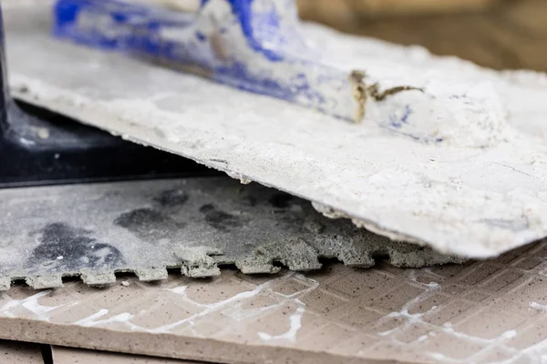 Fayans yere yerleştirmeye ilişkin. Aksesuarları ve malzemeleri Ahşap Atölyesi masanın üzerine düzenlenmiş bir inşaat işçisi. Koyu arka plan