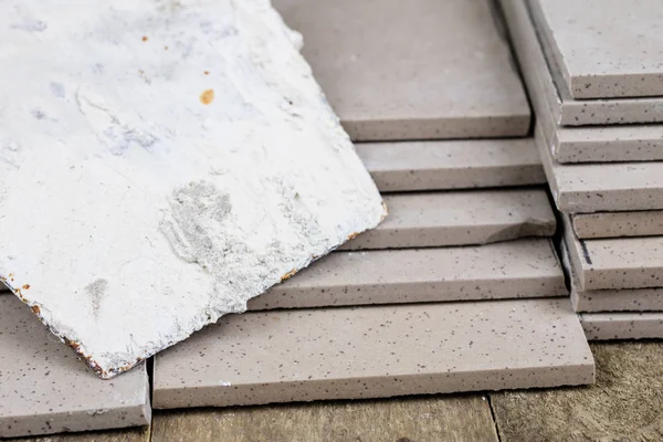 Fayans yere yerleştirmeye ilişkin. Aksesuarları ve malzemeleri Ahşap Atölyesi masanın üzerine düzenlenmiş bir inşaat işçisi. Koyu arka plan