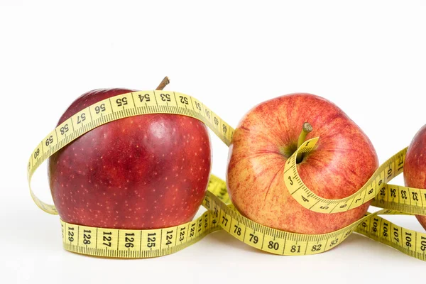 赤いリンゴと白いテーブルでテーラーのメジャー 熟した果物や仕立て屋のセンチメートル 白背景 — ストック写真