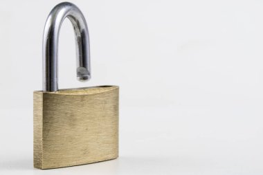 Beyaz bir tablo üzerinde pirinç asma kilit. Kilitleme ve hırsızlık karşı güvenliğini sağlamak için aksesuarlar. Beyaz arka plan.