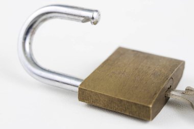 Beyaz bir tablo üzerinde pirinç asma kilit. Kilitleme ve hırsızlık karşı güvenliğini sağlamak için aksesuarlar. Beyaz arka plan.