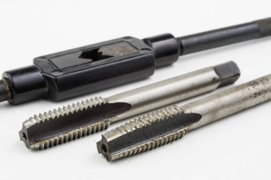 Aygıt içinde bir vida konuları yapmak için. Metal işleme aksesuarları. Beyaz arka plan.