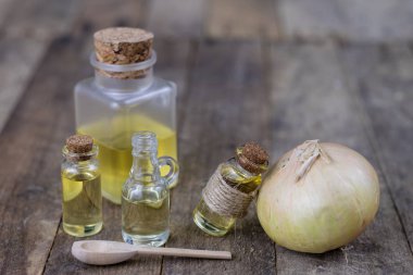 Soğan suyu ve sebzeler üzerinde ahşap bir masa. Ev yapımı şurubu grip tedavisi için. Koyu arka plan.