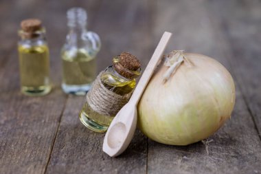 Soğan suyu ve sebzeler üzerinde ahşap bir masa. Ev yapımı şurubu grip tedavisi için. Koyu arka plan.