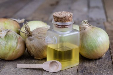 Soğan suyu ve sebzeler üzerinde ahşap bir masa. Ev yapımı şurubu grip tedavisi için. Koyu arka plan.