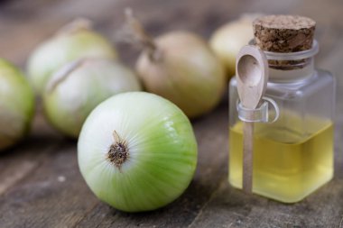 Soğan suyu ve sebzeler üzerinde ahşap bir masa. Ev yapımı şurubu grip tedavisi için. Koyu arka plan.