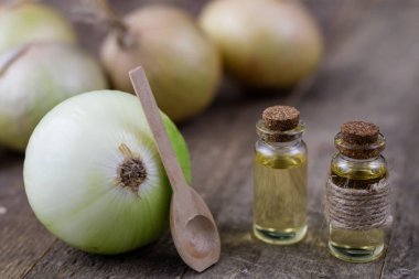 Soğan suyu ve sebzeler üzerinde ahşap bir masa. Ev yapımı şurubu grip tedavisi için. Koyu arka plan.