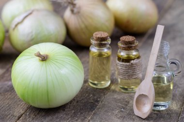 Soğan suyu ve sebzeler üzerinde ahşap bir masa. Ev yapımı şurubu grip tedavisi için. Koyu arka plan.