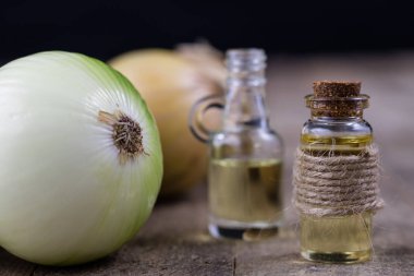 Soğan suyu ve sebzeler üzerinde ahşap bir masa. Ev yapımı şurubu grip tedavisi için. Koyu arka plan.