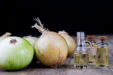 Soğan suyu ve sebzeler üzerinde ahşap bir masa. Ev yapımı şurubu grip tedavisi için. Koyu arka plan.