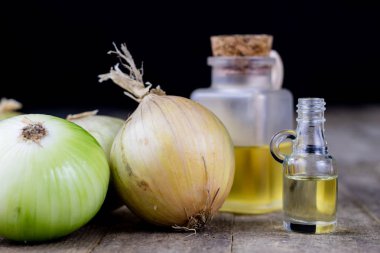 Soğan suyu ve sebzeler üzerinde ahşap bir masa. Ev yapımı şurubu grip tedavisi için. Koyu arka plan.