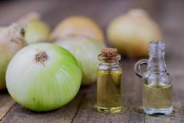 Soğan suyu ve sebzeler üzerinde ahşap bir masa. Ev yapımı şurubu grip tedavisi için. Koyu arka plan.