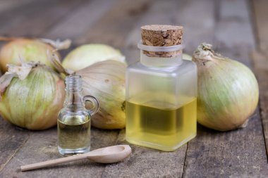 Soğan suyu ve sebzeler üzerinde ahşap bir masa. Ev yapımı şurubu grip tedavisi için. Koyu arka plan.