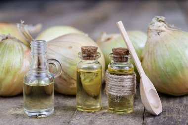 Soğan suyu ve sebzeler üzerinde ahşap bir masa. Ev yapımı şurubu grip tedavisi için. Koyu arka plan.