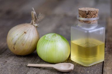 Soğan suyu ve sebzeler üzerinde ahşap bir masa. Ev yapımı şurubu grip tedavisi için. Koyu arka plan.