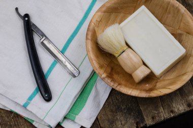 Jilet, fırça ve sabun eski ahşap masa. Erkekler için günlük hijyen için aksesuarlar. Koyu arka plan.