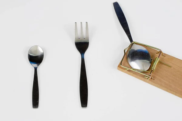 餐具和捕鼠器在一个白色的桌子上 叉子和勺子夹在陷阱里 白色背景 — 图库照片
