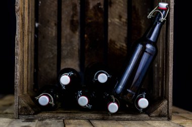 Eski şişe ahşap bir durumda. Eski Cam kaplarda içer. Koyu arka plan.