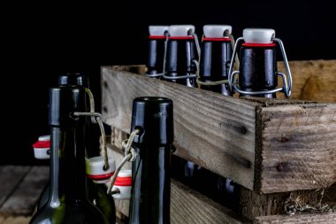 Eski şişe ahşap bir durumda. Eski Cam kaplarda içer. Koyu arka plan.