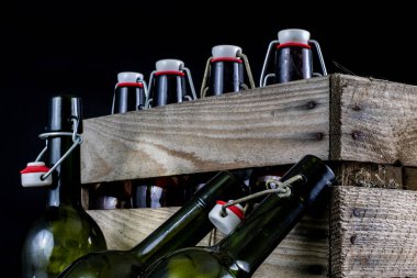 Eski şişe ahşap bir durumda. Eski Cam kaplarda içer. Koyu arka plan.