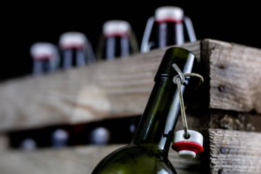 Eski şişe ahşap bir durumda. Eski Cam kaplarda içer. Koyu arka plan.