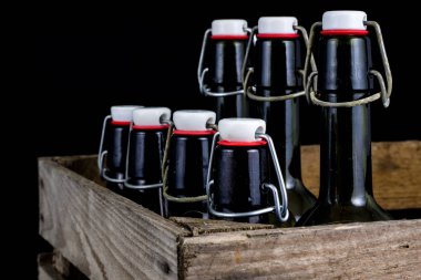 Eski şişe ahşap bir durumda. Eski Cam kaplarda içer. Koyu arka plan.