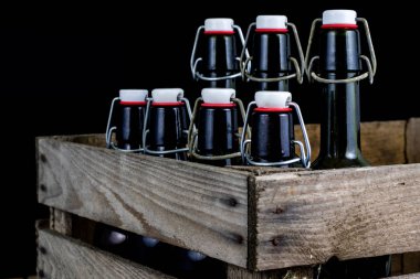 Eski şişe ahşap bir durumda. Eski Cam kaplarda içer. Koyu arka plan.