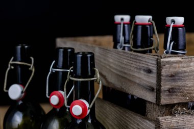 Eski şişe ahşap bir durumda. Eski Cam kaplarda içer. Koyu arka plan.