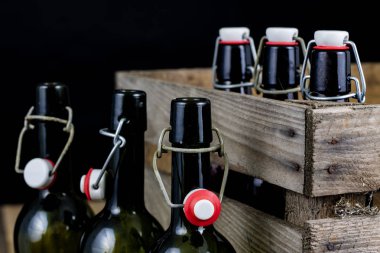 Eski şişe ahşap bir durumda. Eski Cam kaplarda içer. Koyu arka plan.