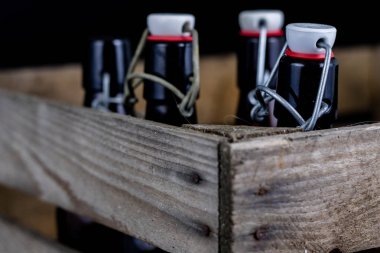 Eski şişe ahşap bir durumda. Eski Cam kaplarda içer. Koyu arka plan.