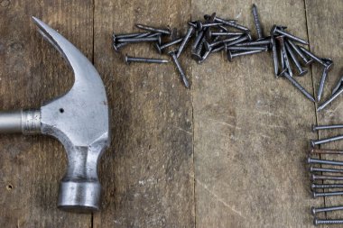 Çekiç ve çivi bir ahşap Atölyesi tablo. Sanayi aksesuar DIY bir atölye. Koyu arka plan.