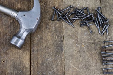 Çekiç ve çivi bir ahşap Atölyesi tablo. Sanayi aksesuar DIY bir atölye. Koyu arka plan.