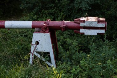 Eski istasyonun yanındaki demiryolu bariyeri. Yolda demiryolu bariyeri. Yaz mevsimi.