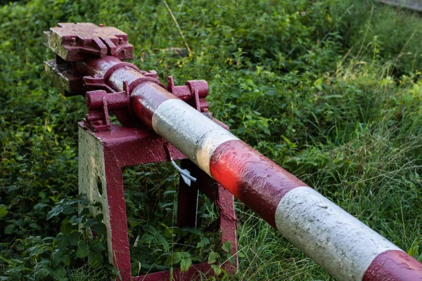 Eski istasyonun yanındaki demiryolu bariyeri. Yolda demiryolu bariyeri. Yaz mevsimi.