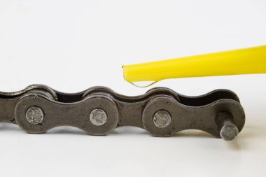 Bisiklet zincirini sıvı yağlayıcı ile yağlayın. İki tekerlekli parçalar için periyodik servis. Açık arka plan.