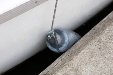 Tamponlar yat tarafında asılı. Demirli ve güvenli tekne gölün üzerinde iskelede. Yaz sezonu.