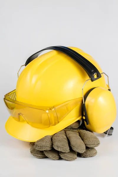 ヘルメットと白いテーブルで聴覚保護 建設労働者の安全と衛生のアクセサリー 白背景 — ストック写真