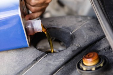 Arabanın motoru için yağ boşaltma. Sıvı arabanın sürücü biriminde ilave. Yer - araba atölye.