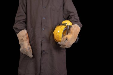 Elinde bir koruyucu önlük giyen bir kask ile çalışan. Sağlık koruma çalışanlar. Koyu arka plan.