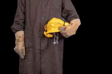 Elinde bir koruyucu önlük giyen bir kask ile çalışan. Sağlık koruma çalışanlar. Koyu arka plan.
