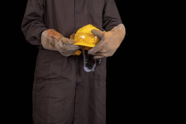 Elinde bir koruyucu önlük giyen bir kask ile çalışan. Sağlık koruma çalışanlar. Koyu arka plan.