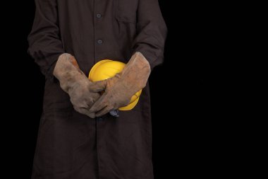 Elinde bir koruyucu önlük giyen bir kask ile çalışan. Sağlık koruma çalışanlar. Koyu arka plan.